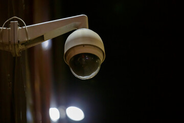 360 degree ball surveillance security camera on building wall at night
