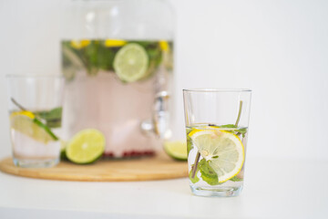 Summer cooling drink with berries and citrus. Lemonade in a reusable glass bottle and glasses. Homemade drink with mint, lime and lemon. Medicinal and healthy drink with vitamin C