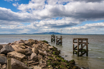 The entrance to the harbour with the coast of Scotland in the background, seen from the West Beach in Silloth, Cumbria, England, UK