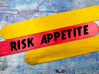 Business concept.Text RISK APPETITE writing on colored ice cream sticks on a wooden background.