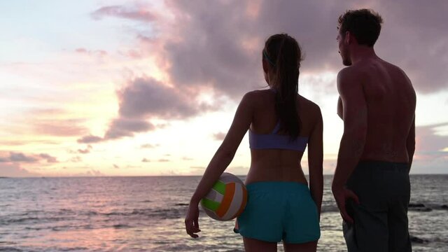 Friends talking after beach volleyball active fun living sporty active lifestyle. Portrait of people with volley ball after game in summer. Woman and man fitness model enjoying sunset