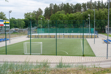 Fototapeta premium Green soccer field with blue seats. Sports stadium.