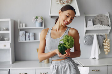 Beautiful and sporty girl in a kitchen with a vegetables