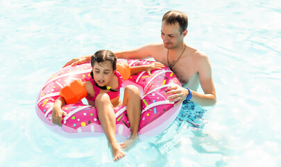 Happy family playing in swimming pool. Summer vacation concept