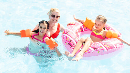 Happy family playing in swimming pool. Summer vacation concept