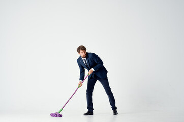 business man in a suit washes the floors with a mop cleaning