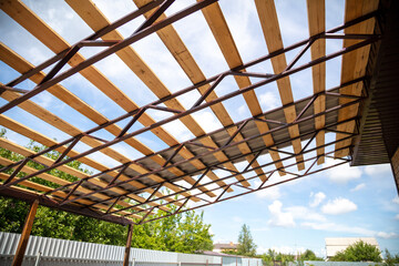 Workers install a metal shed on a wooden frame.
