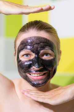 Black acne mask on the face of a smiling young girl. Close-up photo.
