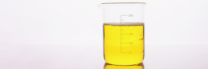 Clear yellow liquid is poured into beaker