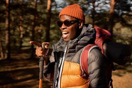 Funny Black Man In Good Mood Pointing With Finger, Hand Gesture. Cheerful Guy In Sportswear Ready For Camping, Hiking And Active Pastime. Wildlife, Travel Alone, Explore Peaceful Places Concept