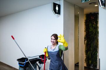 Young woman cleaning at shopping mall. Cleaning concept.