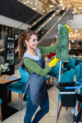 Young woman cleaning at shopping mall. Cleaning concept.