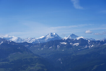 Fototapeta na wymiar Panoramic view of Swiss alps with Mountains Eiger, Mönch (Monk) and Jungfrau (Virgin) on a beautiful sunny summer day seen from Brienzer Rothorn. Photo taken July 21st, Flühli, Switzerland.