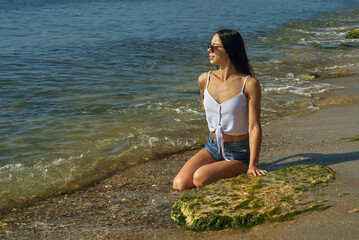 A happy young woman on the sea beach . Summer vacation .