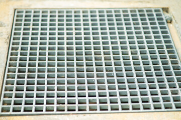Closeup drain sump and grating on the floor in outdoor.