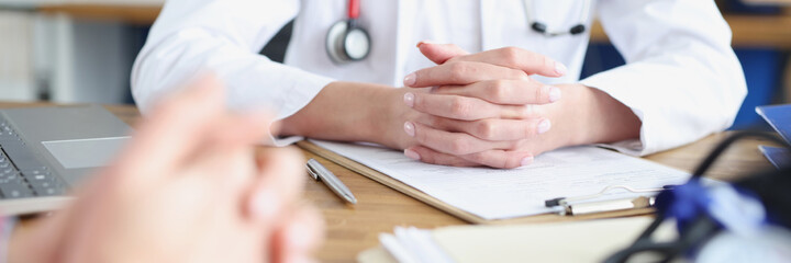 Hands of doctor and patient on work table in medical office