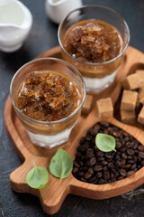 Glasses with coffee granita on a wooden serving tray, close-up, vertical shot on a dark brown stone surface, selective focus