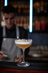 barman is making cocktail decorated with an flower