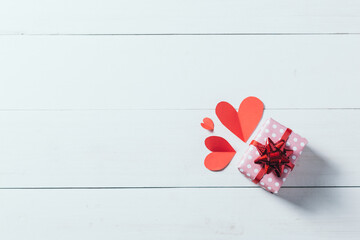 Pink gift box and paper of heart on wooden white plank, Happy Valentine's day concept.