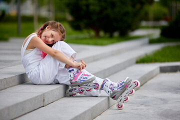 cute little girl on roller skates at park.
