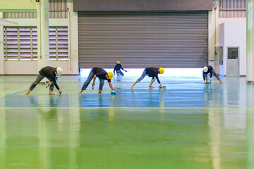Construction workers are using trowel spreading moisture blocking epoxy primer for Self-leveling...