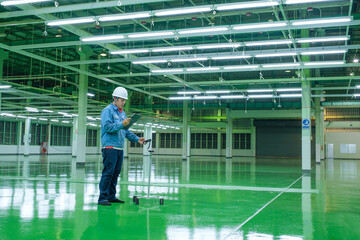 Electrical inspector engineer using lux meter for testing illuminance lighting of production line...
