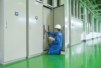 Electrical inspector engineer checking status multi meter of distribution board load panel at...