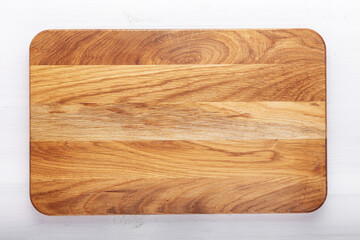 Rectangular cutting board on a white wooden table. Food preparation tool and kitchen utensils.