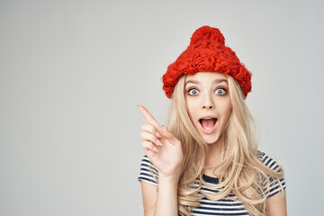 cheerful blonde in a red hat gesturing with her hands emotions