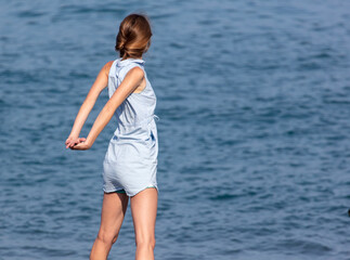 Fototapeta na wymiar The girl does exercises on the seashore.