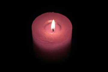 Candle burning in darkness, color red