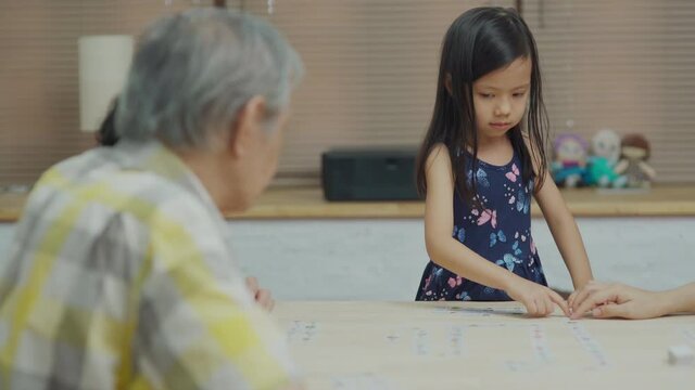 Happy Multi Generation Asia Family Sitting And Playing Board Game Laughing Together