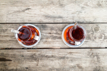 Two Glass of tea isolated on a natural brown hardwood table. Textured Wallpaper.