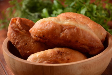 Russian Patties (Pasties, Hot Cakes, Pirozhki, Pies) on wooden cupboard . Traditional homemade fried pies  with potatoes