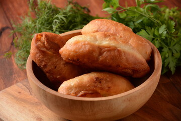 Russian Patties (Pasties, Hot Cakes, Pirozhki, Pies) on wooden cupboard . Traditional homemade fried pies  with potatoes