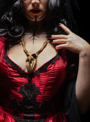 Gothic witch with runic makeup and wooden animal skull amulet on her chest. Halloween concept, black magic.