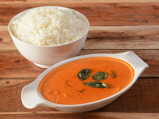 THAI RED CURRY. Thailand tradition red curry soup with steamed rice, served over a rustic wooden table, selective focus