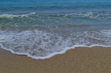 Sandy beach, beautiful sea waves. White sea foam.