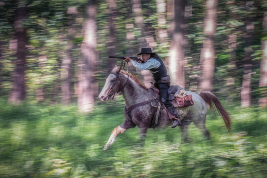 Panning photography techniques by set camera to a slow shutter speed and move to follow a moving subject while pressing shutter. Resulting image can be seen as a cowboy is riding a horse moving fast.