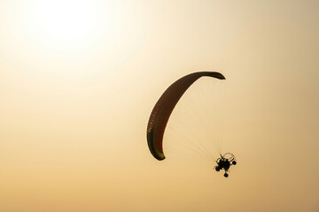 Tilted paramotor vehicle for flying around in a sunny yellow sky