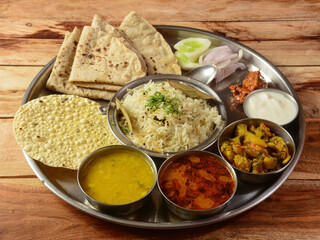 Veg Thali from an indian cuisine, food platter consists variety of veggies,paneer dish, lentils,rice,roti, sweet dish, snacks etc., selective focus