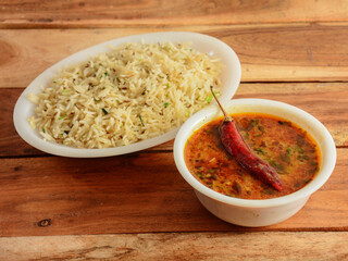 Indian combo meal Dal tadka with Naan, served over a rustic wooden background, selective focus