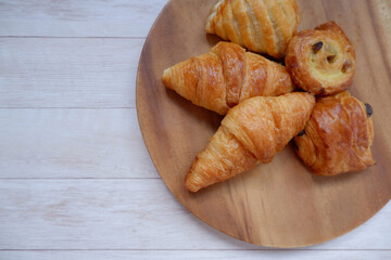 Croissant and Breads on wooden plate. breakfast, Bread dishes, meal background.