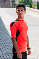 Young latin man in sportswear standing looking backwards on a ramp