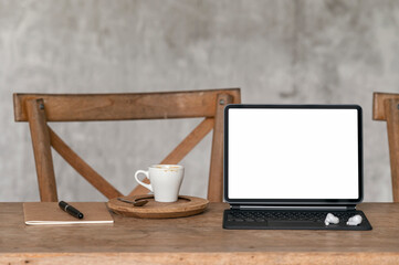 Mockup blank screen tablet with magic keyboard on wooden table, creative workspace in loft style.