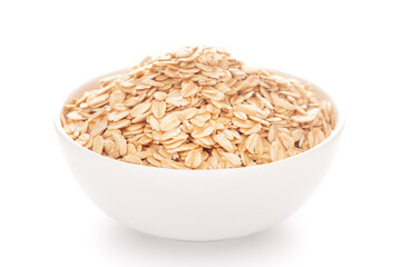 Close-up of dry organic whole rolled oats (Avena sativa) roasted in a white ceramic bowl over white background.