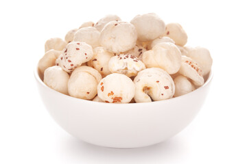 Close-up of organic makhane (puffed lotus seed or Fox nuts)  in a white ceramic bowl over white background.