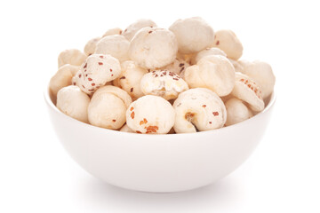 Close-up of organic makhane (puffed lotus seed or Fox nuts)  in a white ceramic bowl over white...