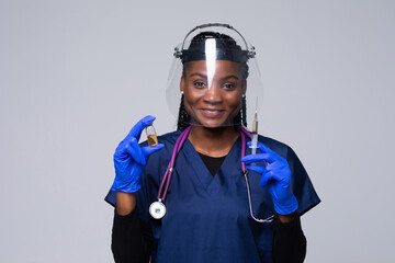 Medicine, vaccination and healthcare concept, African american female doctor or scientist in mask with syringe over grey background