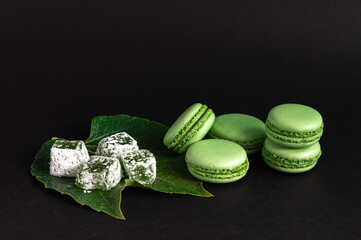 French macaroons and turkish delight on black background